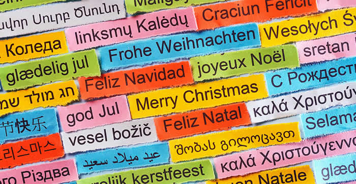Immagine con tanti biglietti colorati con la scritta Buon Natale nelle diverse lingue europee, per auguri internazionali
